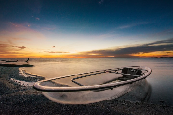 a boat sitting on top of a sandy beach