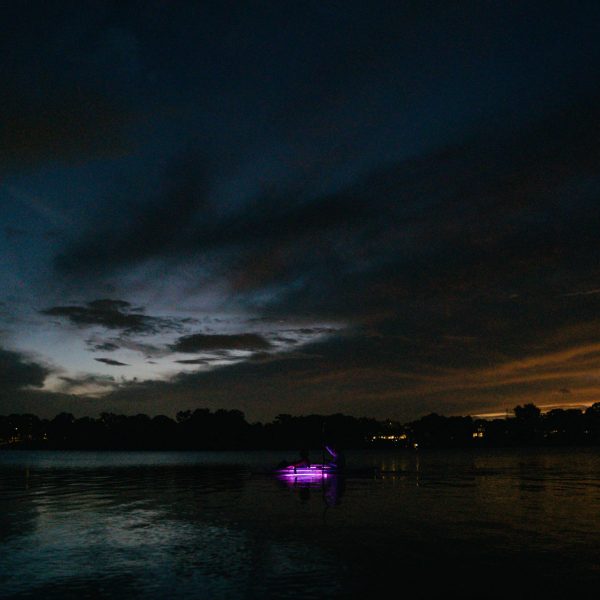 a group of clouds in the night sky over a body of water