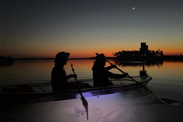 a group of people standing next to a body of water