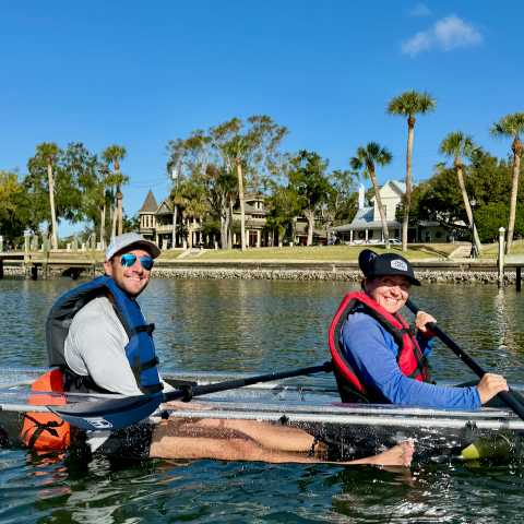 a group of people rowing a boat in the water