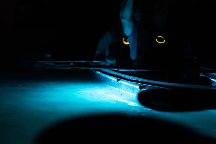 a person riding a surf board in the dark