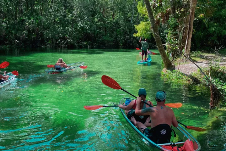 a group of people riding on the back of a boat in the water