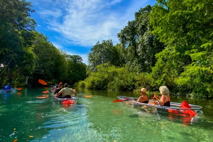 a group of people riding on the back of a boat in the water