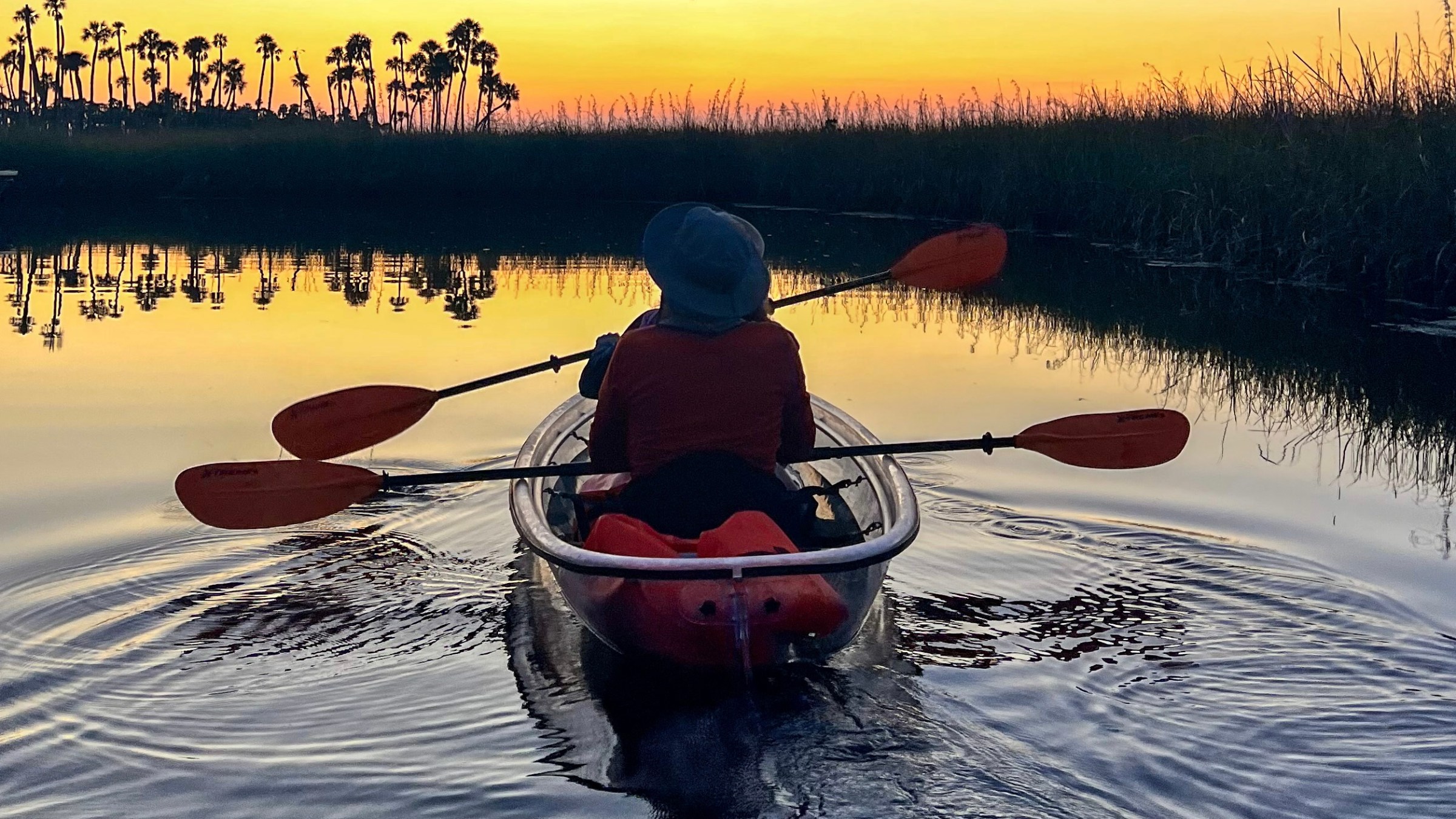 WeekiWacheeSunsetandGlowKayakTourPicture1 a person riding on the back of a boat in a body of water