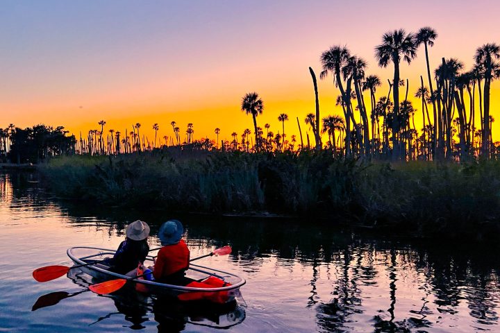 a group of people in a small boat in a body of water