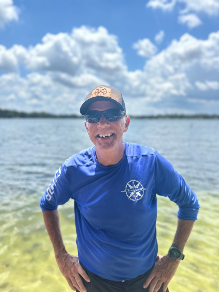 a man standing next to a body of water