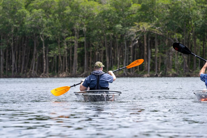 a group of people rowing a boat in the water
