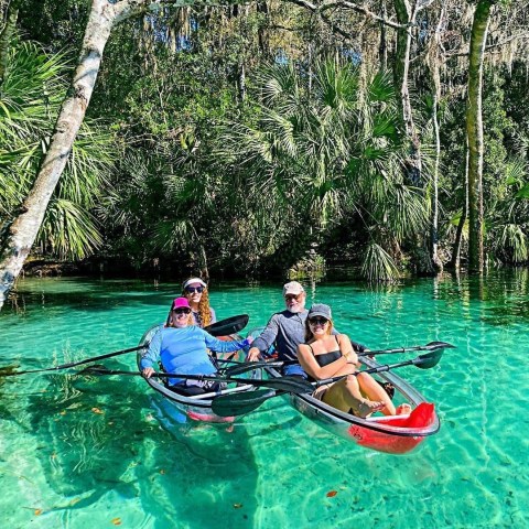 a group of people riding on the back of a boat in the water