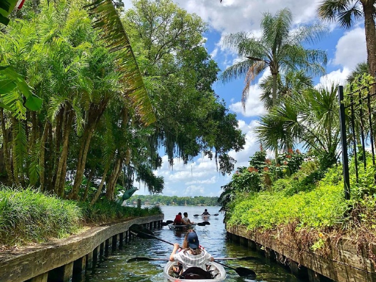 a boat floating along a river next to a body of water