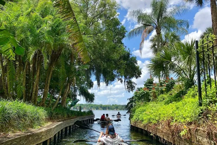 a boat floating along a river next to a body of water