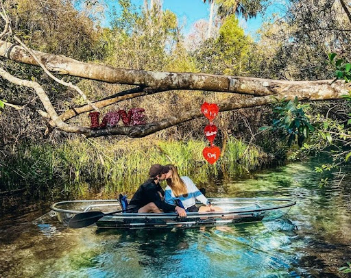 a man riding on the back of a boat next to a river