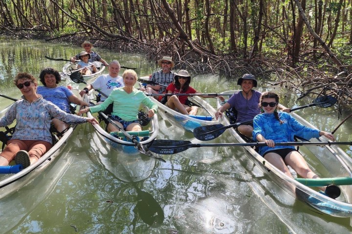 a group of people rowing a boat in the water