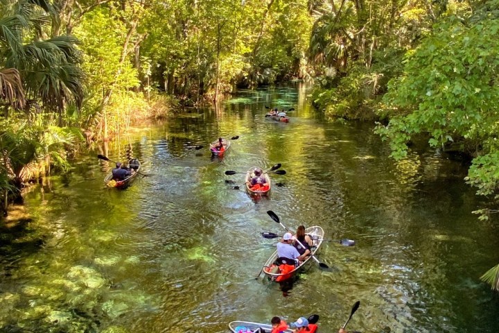 a man riding a motorcycle down a river next to a body of water