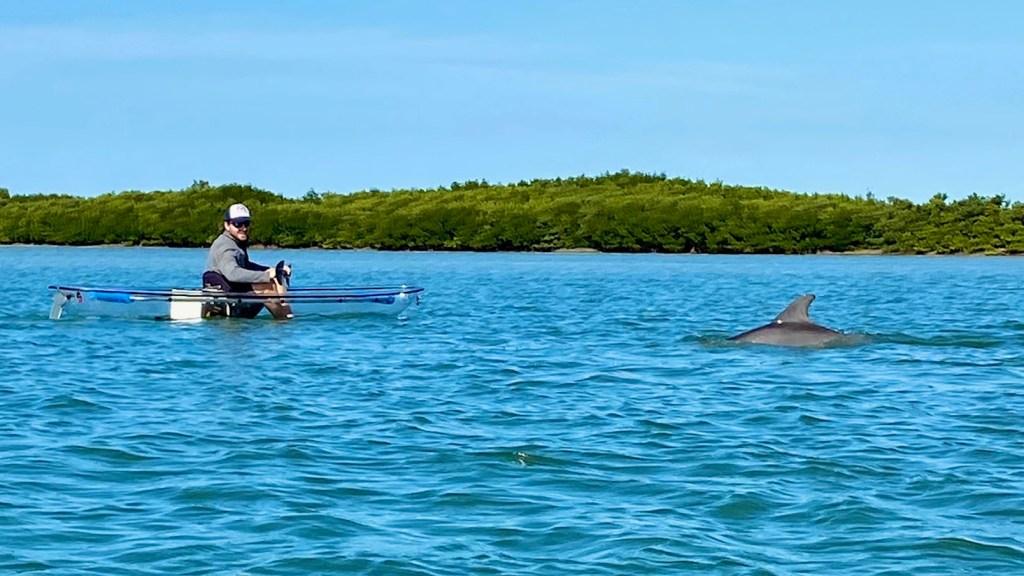 a group of people rowing a boat in a body of water