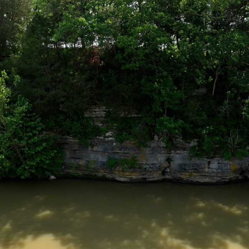 a waterfall with trees on the side of a river