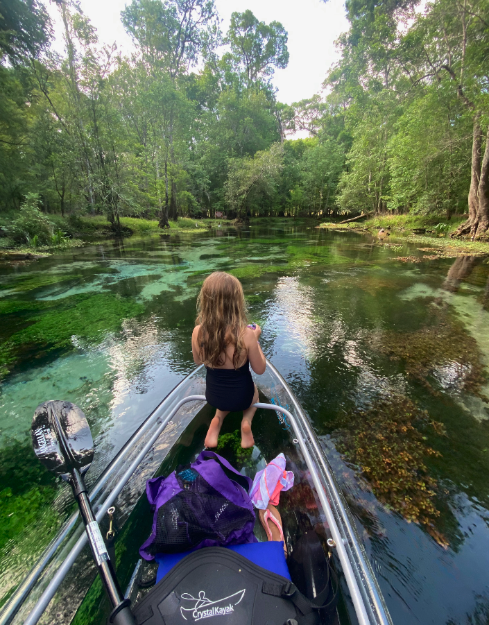 a woman sitting next to a body of water