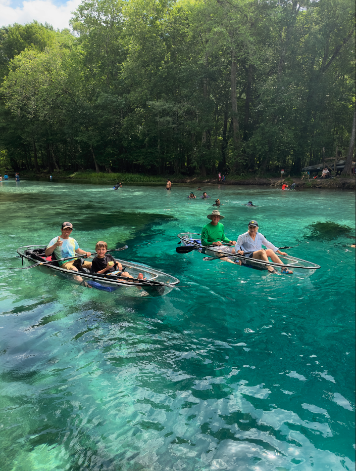 a group of people riding on the back of a boat in the water