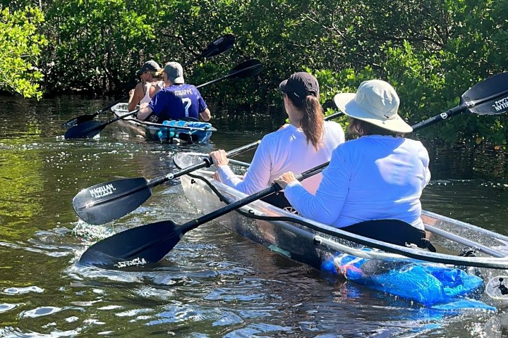 a group of people rowing a boat in the water