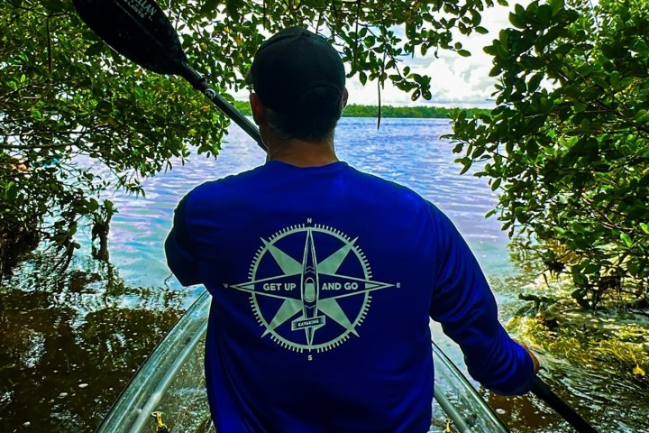 a man standing next to a body of water