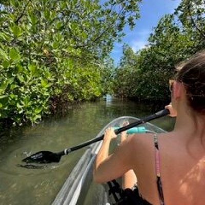 a woman sitting on a motorcycle in front of a body of water