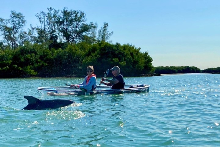 a man riding on the back of a boat in the water