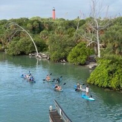 a group of people on a boat in the water with Xelha in the background