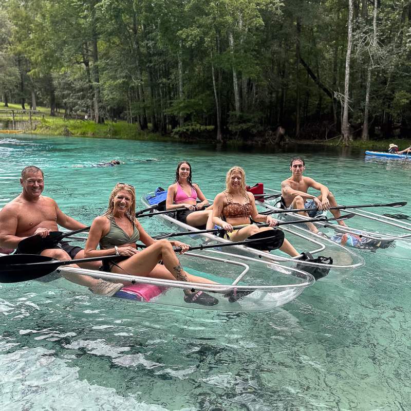a group of people riding on the back of a boat in the water