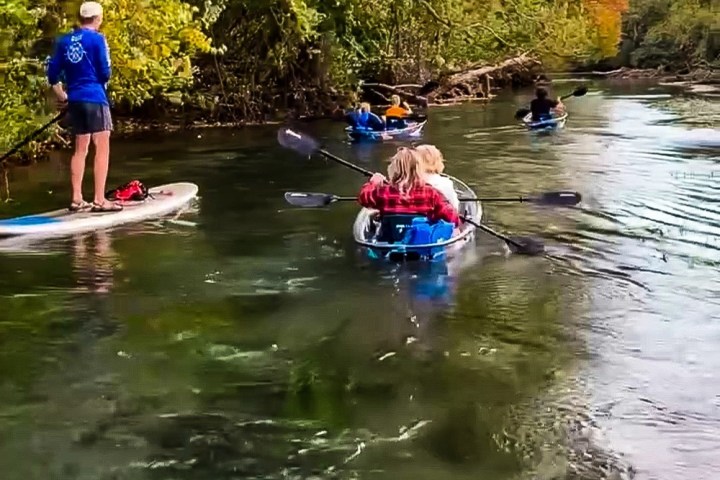 a group of people riding on the back of a boat in the water