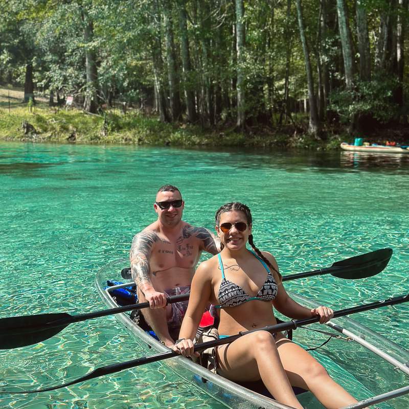 a woman sitting next to a lake
