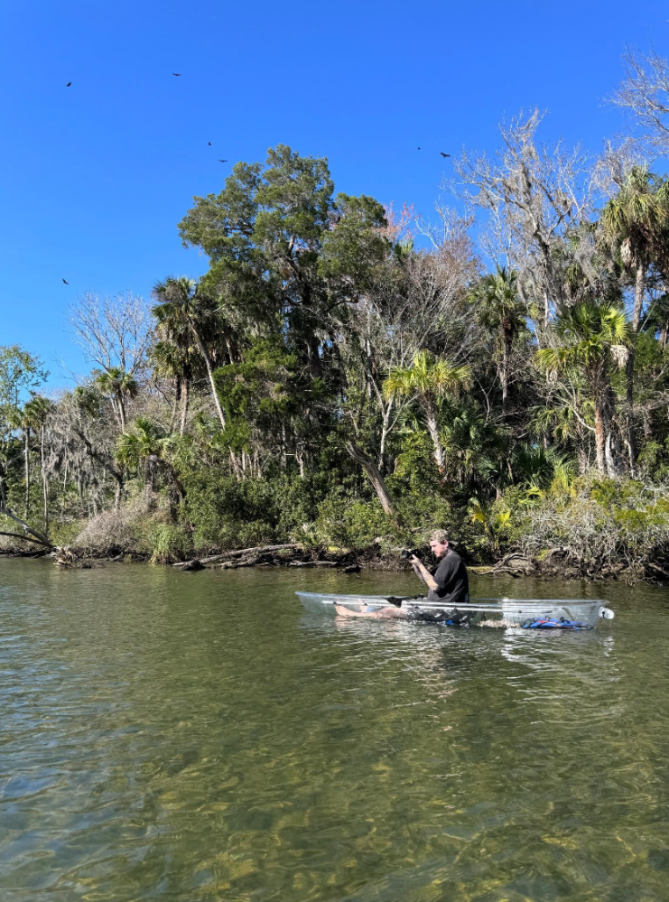 a man riding on the back of a boat in a body of water