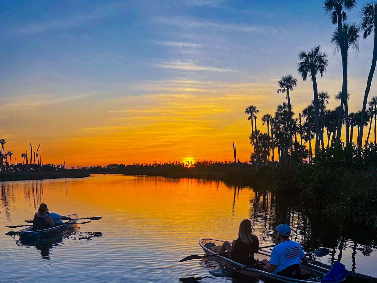 a boat floating along a river next to a body of water