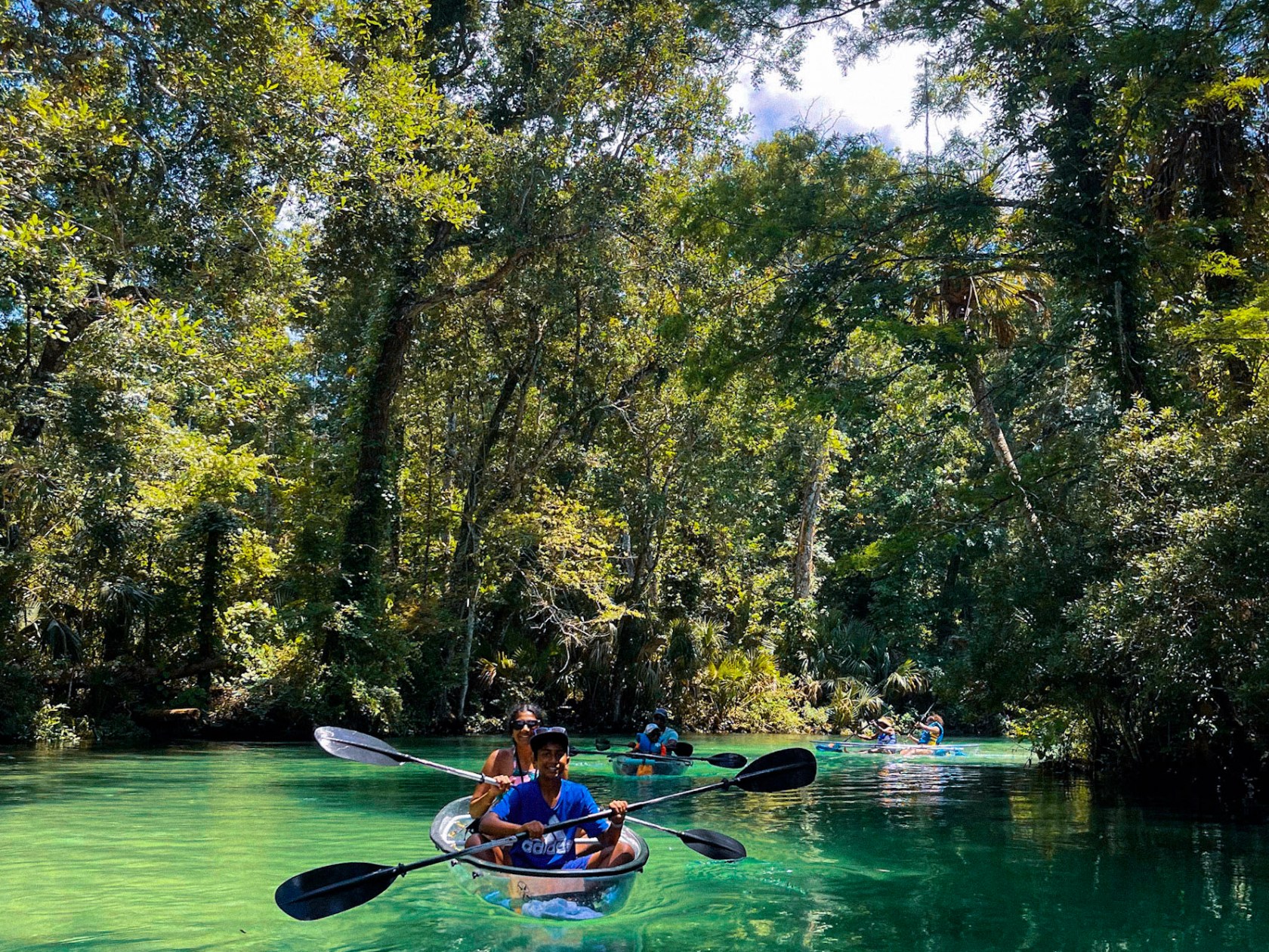 a group of people riding on the back of a boat in the water