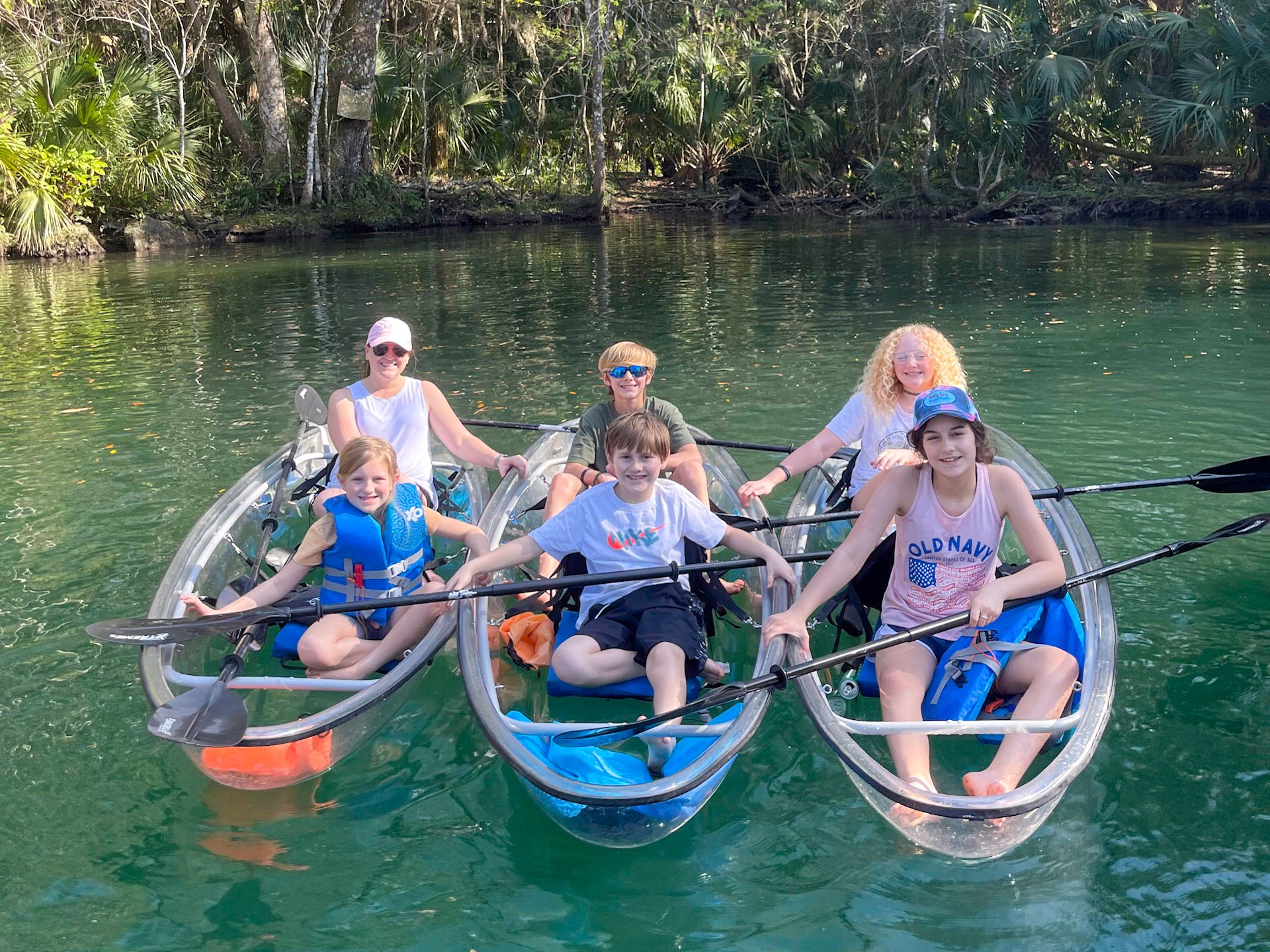 a group of people riding on the back of a boat in the water