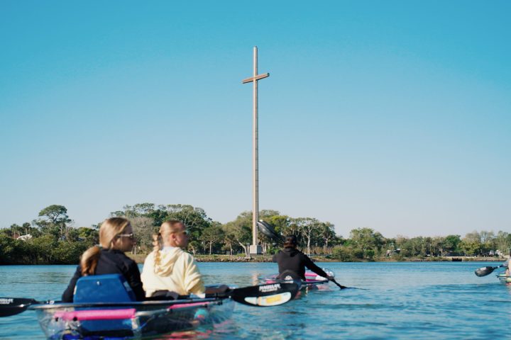 a group of people rowing a boat in a body of water