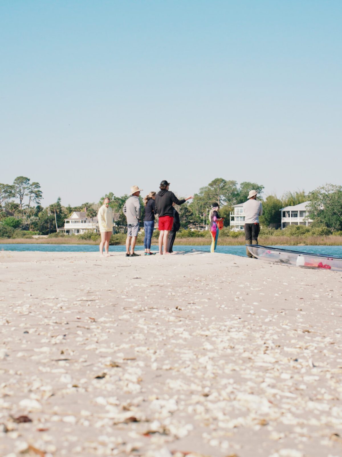 a group of people standing on top of a sandy beach