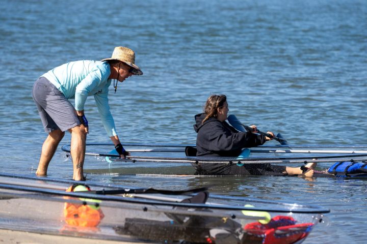 a group of people rowing a boat in the water