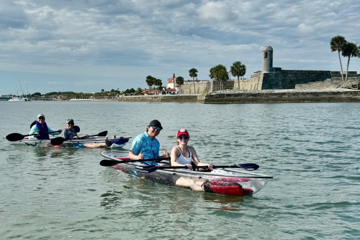 a group of people rowing a boat in the water