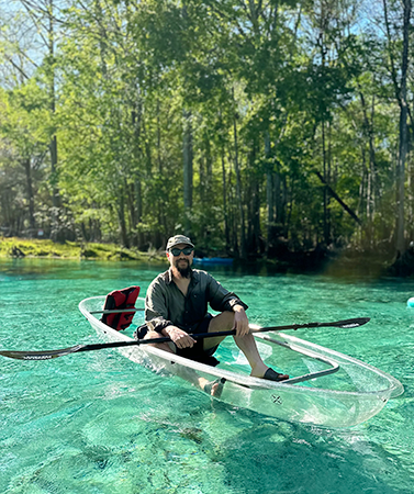 a man riding on the back of a boat in the water