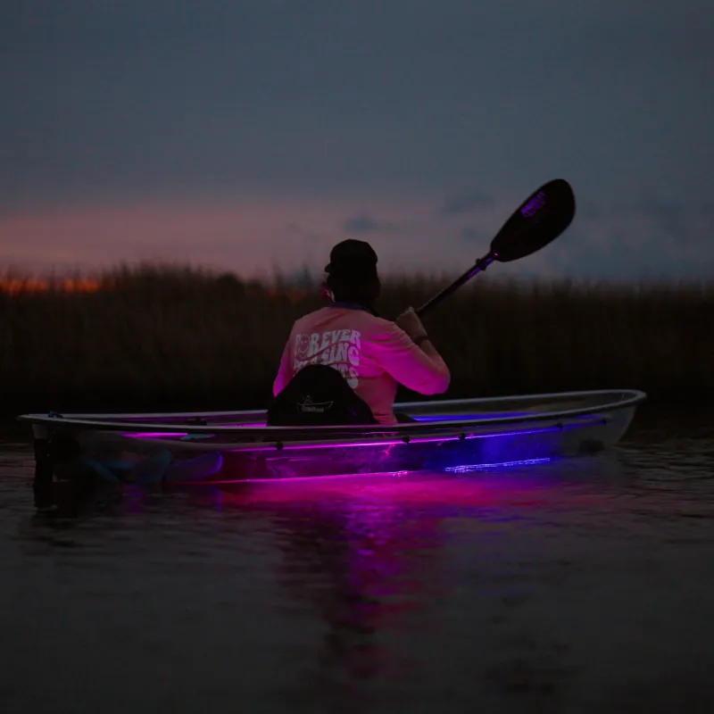 a man riding on the back of a boat in the water