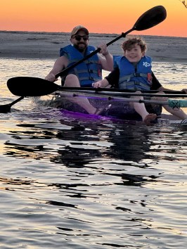 a group of people rowing a boat in the water