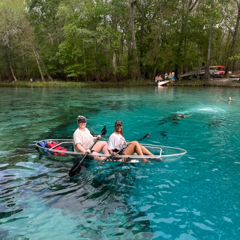a group of people riding on the back of a boat in the water