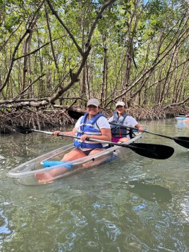 a group of people riding on the back of a boat in the water