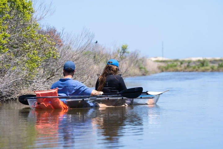 a man riding on the back of a boat in the water