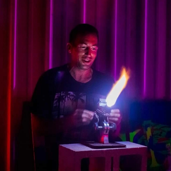 a person standing in front of a cake with lit candles