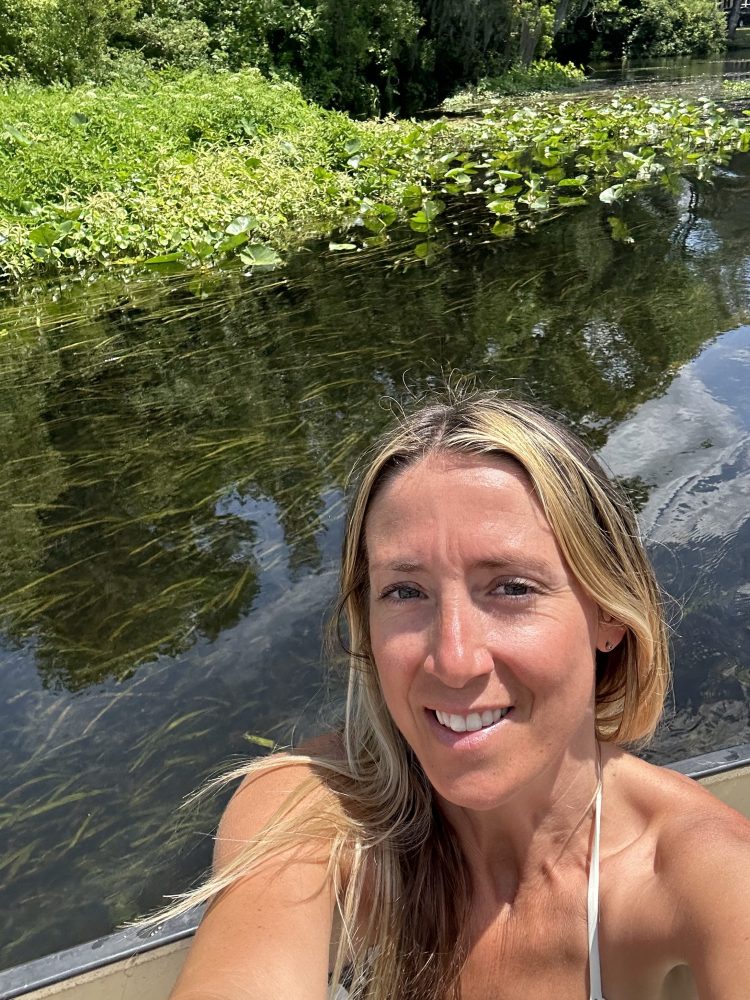 a woman standing next to a body of water