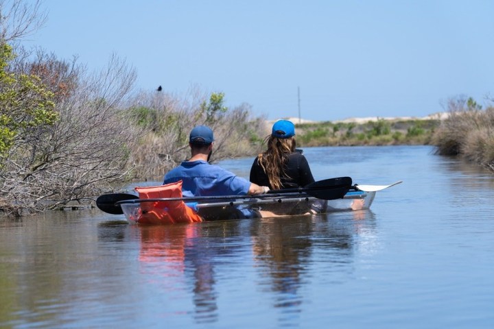 a man riding on the back of a boat in the water