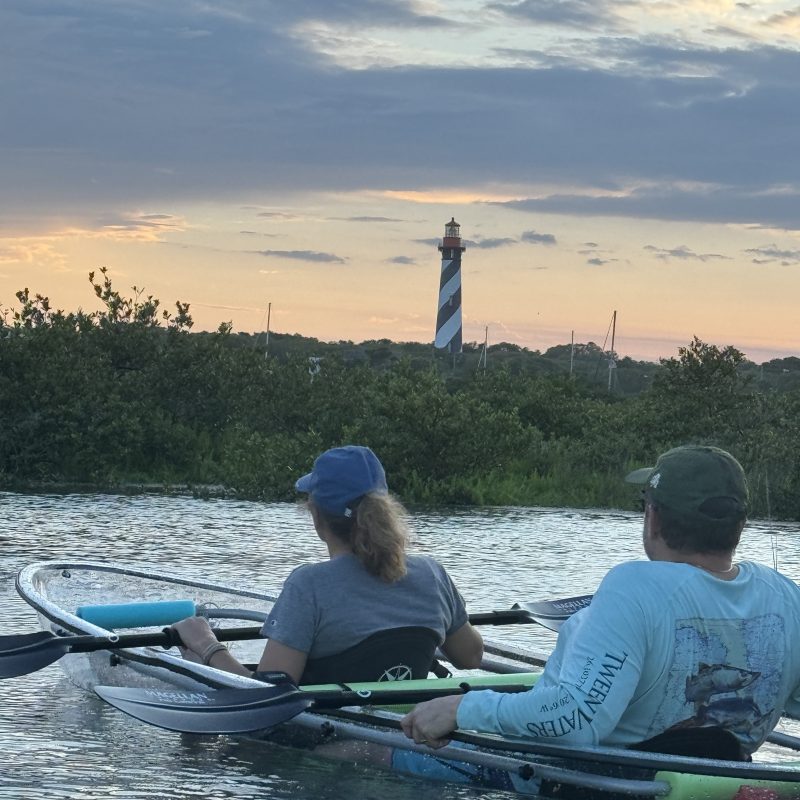 a group of people rowing a boat in the water