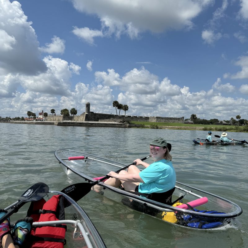 a group of people rowing a boat in a body of water