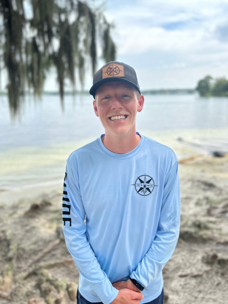 a man standing next to a body of water