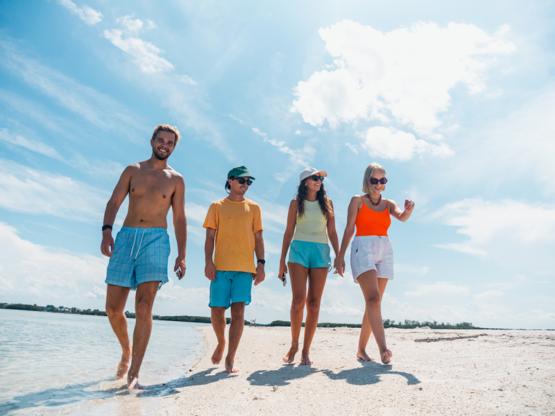 a group of people standing on top of a sandy beach